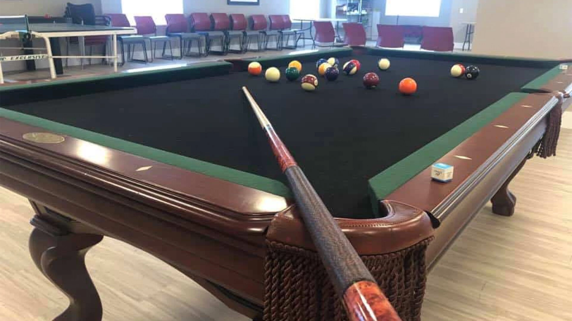 A pool stick laying on a pool table