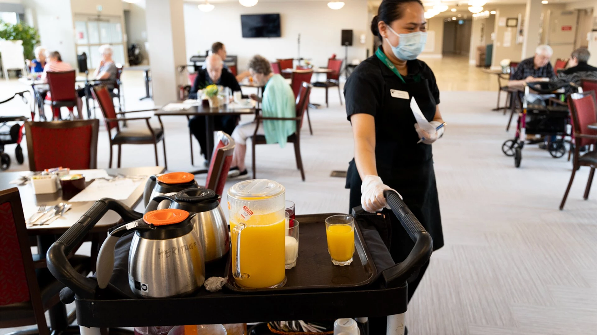 A worker serving orange juice and coffee in Breakfast